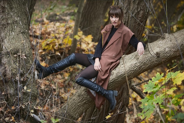 Young girl sitting outdoor in autumn scenery Fashion