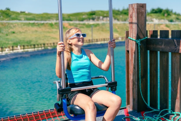 Young girl on skydiver ride Sitting and smiling Lake on a mountain in background