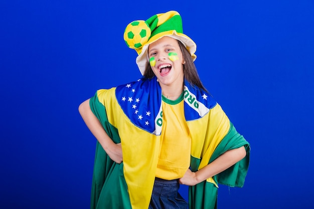 Young girl soccer fan from Brazil dressed in hat and flag