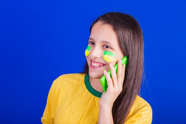 Young girl soccer fan from Brazil holding cellphone voice call Smartphone applications