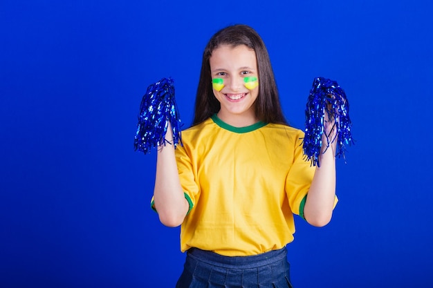 Young girl soccer fan from Brazil holding cheerleader pompom