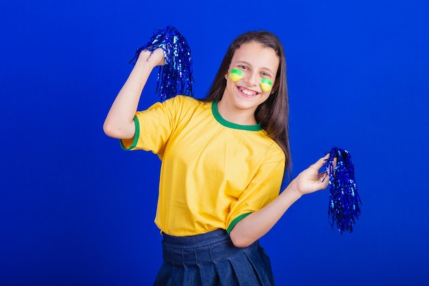 Young girl soccer fan from Brazil holding cheerleader pompom