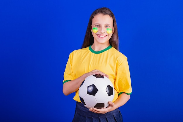 Young girl soccer fan from Brazil holding soccer ball