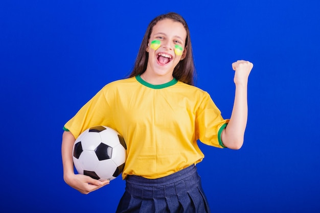 Young girl soccer fan from Brazil holding soccer ball