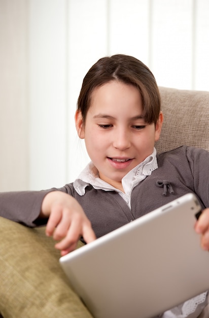 young girl on sofa with touch tablet computer