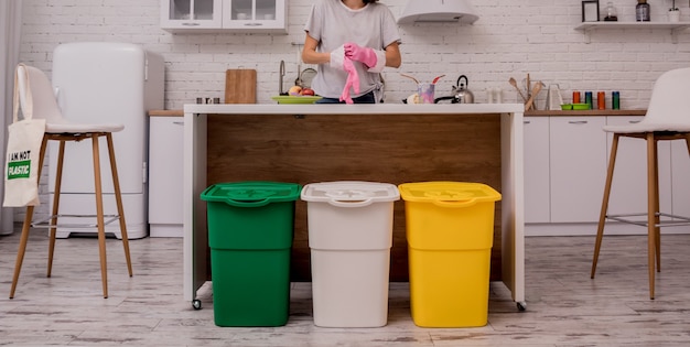 Young girl sorting garbage at the kitchen. Concept of recycling. Zero waste