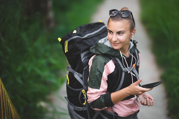 Young girl in a spring jacket and clothes for hiking on the background of the jungle