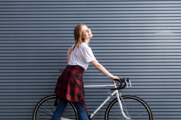 young girl standing with a white bicycle