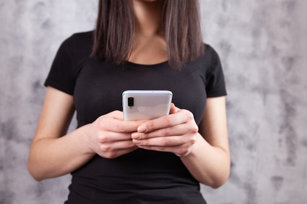 A young girl stands with a phone