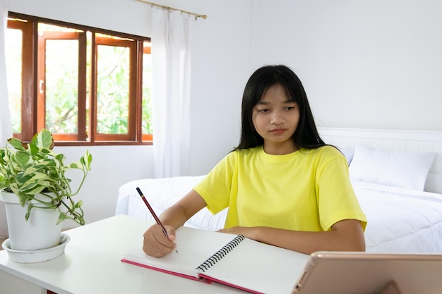 Young girl studying at home student girl doing homework in bedroom at home