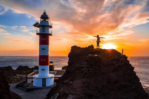 A young girl in the sunset at the Punta de Teno Lighthouse on the island of Tenerife, Canary Islands