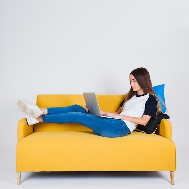 Young girl surffing the web on the sofa