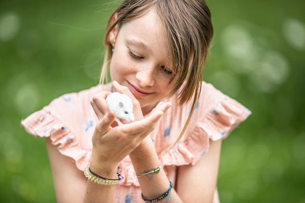 Photo young girl taking care of a small mouse