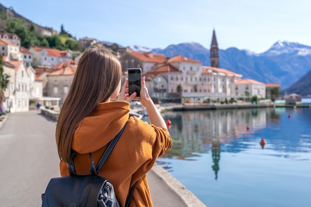 Young Girl Taking Photos Of Landscape With Mobile Smart Phone