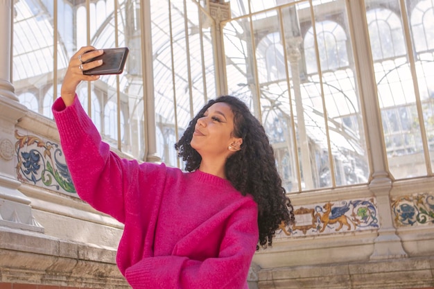 Young girl taking a picture with her phone while waiting for her boyfriend