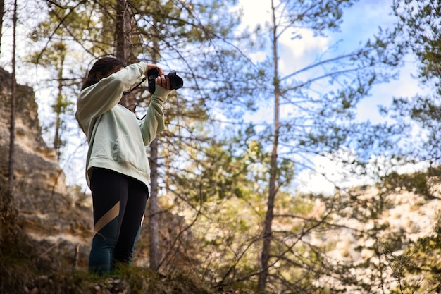 Young girl taking pictures in the forest