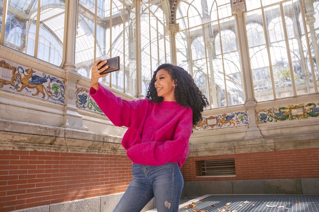 Young girl taking a selfie on her phone while waiting for her boyfriend