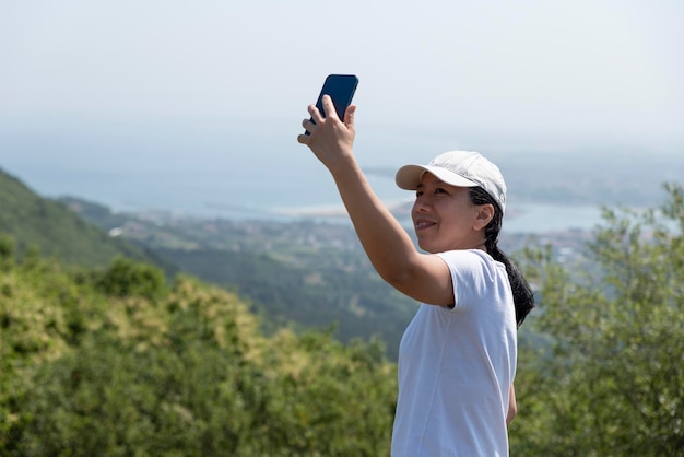 Young girl taking a selfie in the mountains