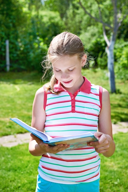 Young girl teenager reading books outdoors