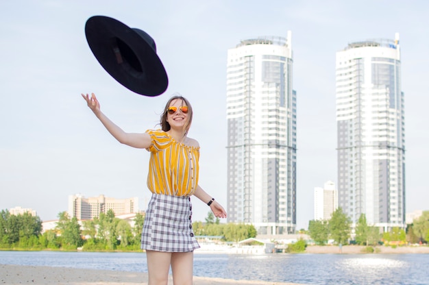 Young girl throws a black hat