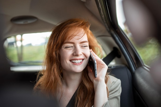 Young girl uses a mobile phone in the car Technology cell phone isolation Internet and social media Woman with smartphone in her car Girl is using a smartphone in car