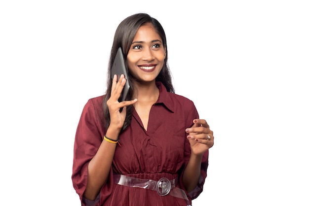 Young girl using mobile phone or smartphone on a white background