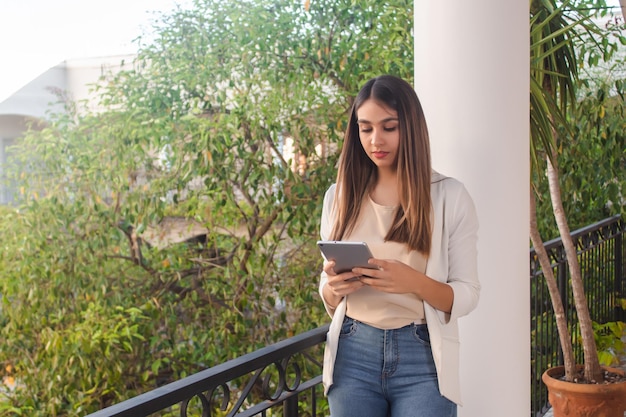 Young girl using a tablet on a hotel balcony