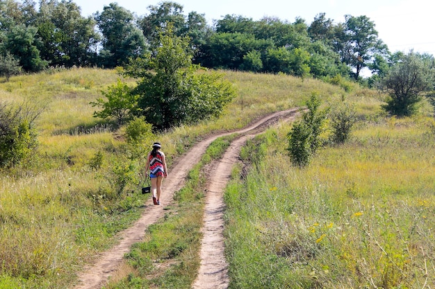 Young girl walking away on the rural road