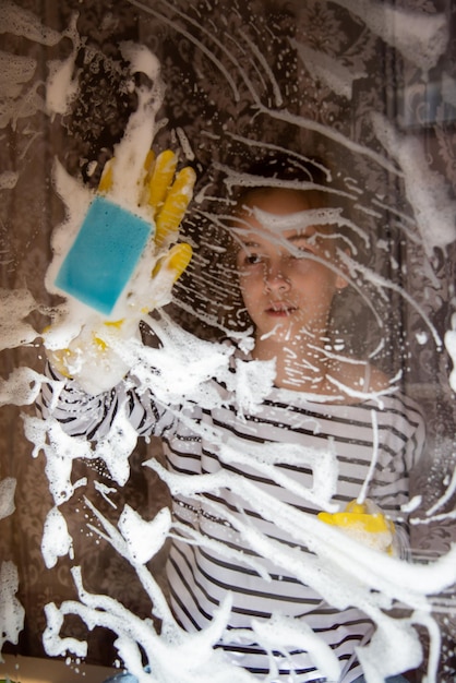 A young girl washes the windows of her house Homework Help Cleaning Lifestile