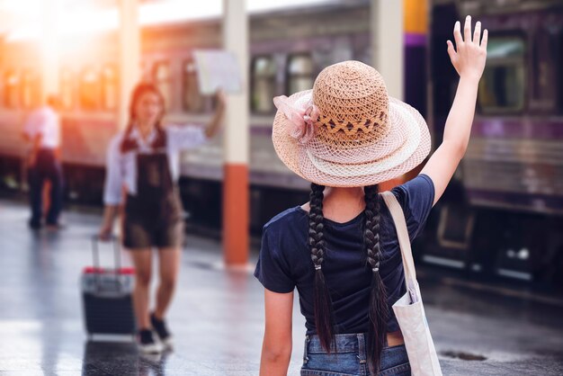 young girl waved to friend at train station