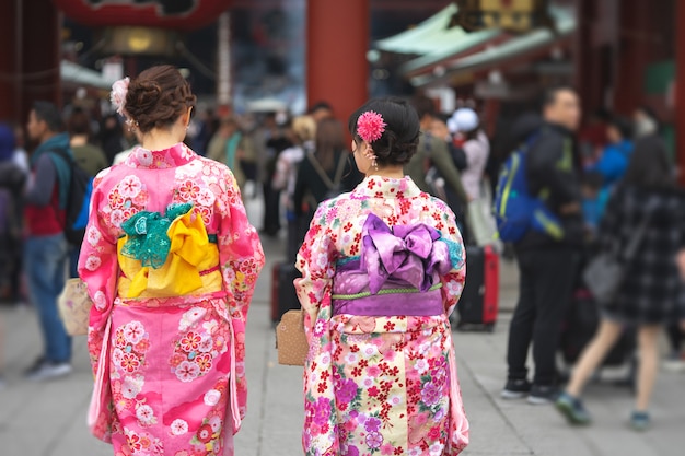 Young girl wearing Japanese kimono standing in front of Sensoji Temple in Tokyo