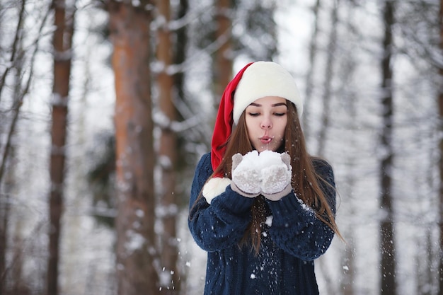 A young girl in a winter park on a walk Christmas holidays in the winter forest The girl enjoys winter in the park