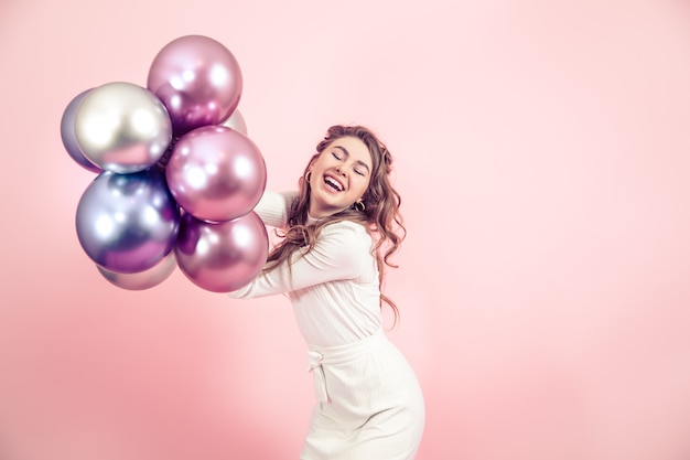 Young girl with balls on a colored wall