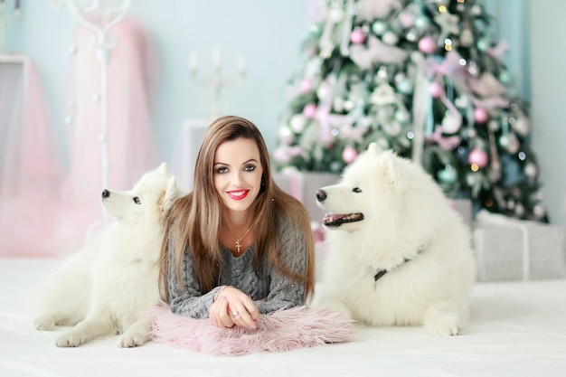 A young girl with a dog near the Christmas tree