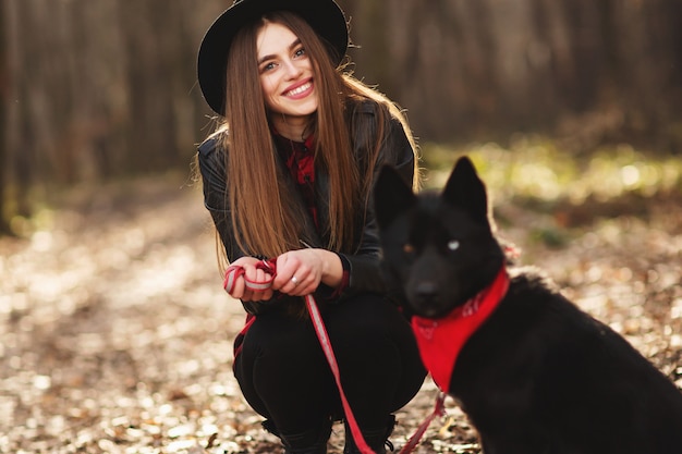 Young girl with a dog walking in the autumn park