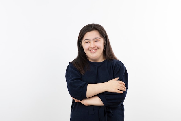 young girl with down syndrome standing arms crossed.