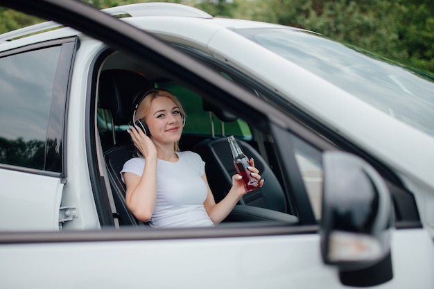 Young girl with headphones listening to music in the car