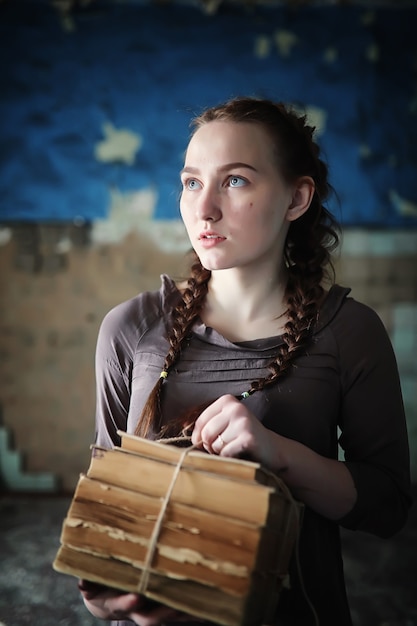 A young girl with old books in the old house