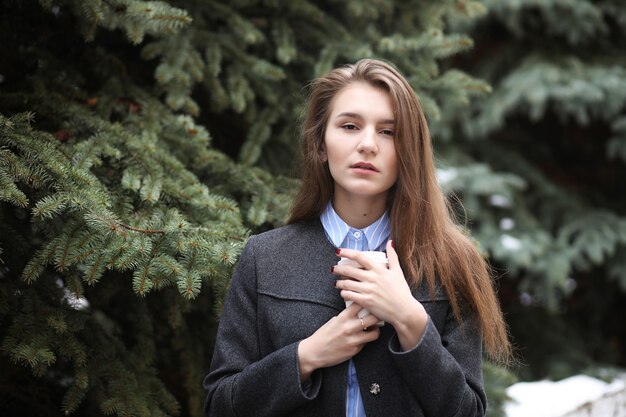 Young girl with a paper cup of coffee outdoor