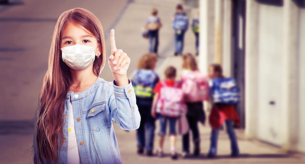 Young girl with protection mask against corona virus at school.