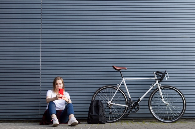 young girl with a smartphone and bicycle