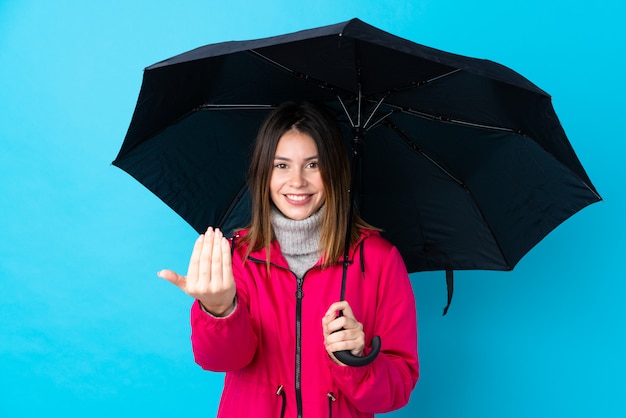 Photo young girl with a umbrella over blue wall