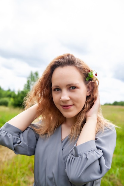 Young girl with wild strawberries in summer day