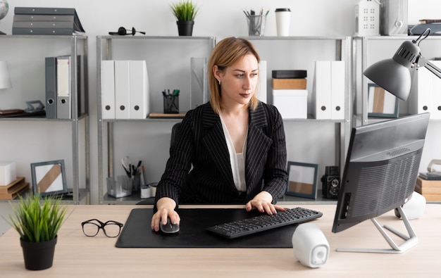 A young girl working at a computer in the office.