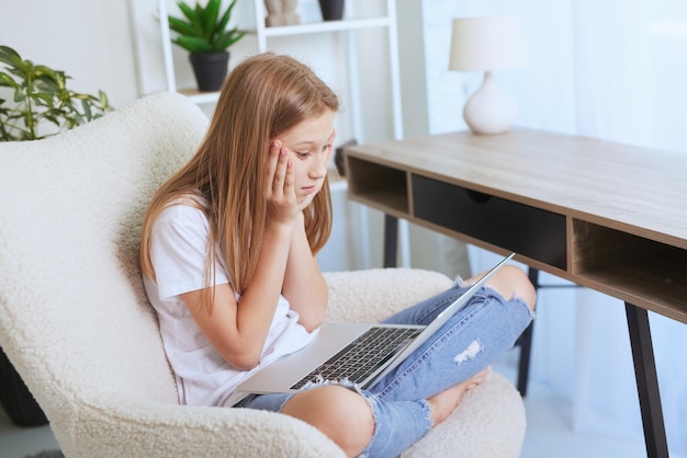 Young girl working at home on a laptop online training