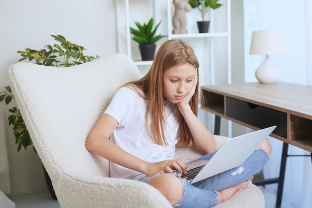 Young girl working at home on a laptop online training