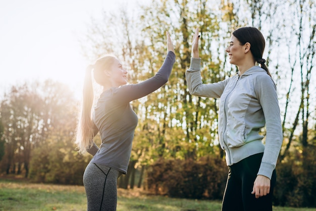 Young girls giving high five to one another while workout outdoors