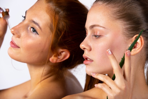 Young girls and posing. Enlarged photo. Girl with aloe leaves and a pipette with serum. Beauty, spa and health concept. High quality photo