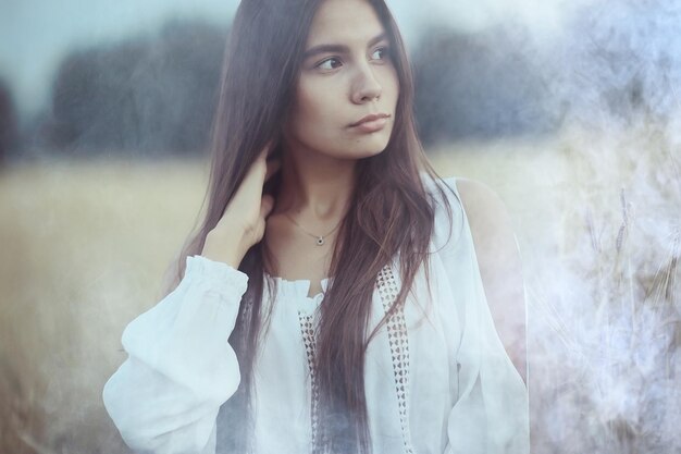 Young glamorous model posing in a field wheat