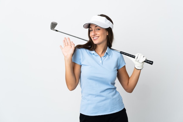 Young golfer woman over isolated white background saluting with hand with happy expression